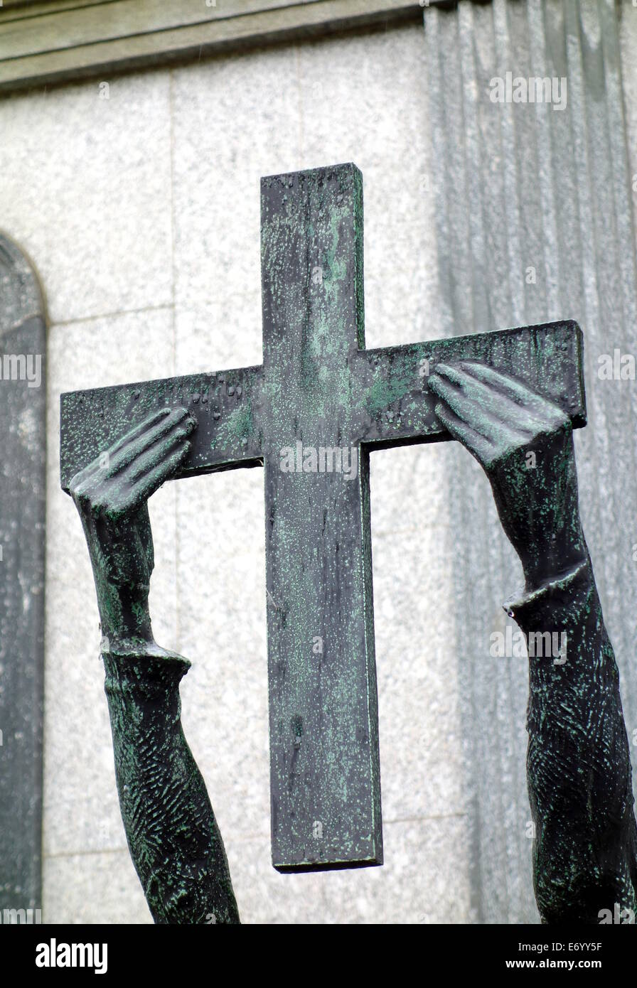 Statue der Hände halten ein Kreuz auf dem Cimitero Monumentale von Mailand, Italien Stockfoto