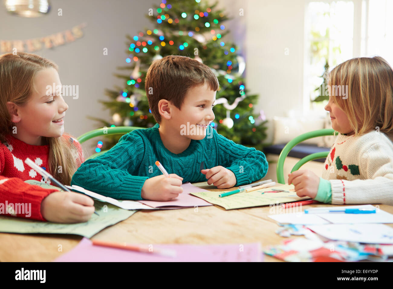 Drei Kinder schreiben Briefe an den Weihnachtsmann zusammen Stockfoto