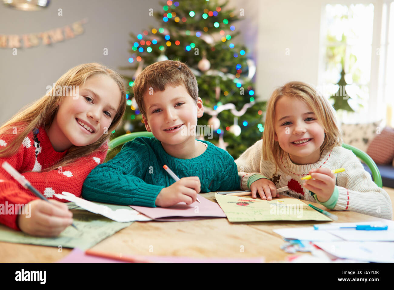Drei Kinder schreiben Briefe an den Weihnachtsmann zusammen Stockfoto