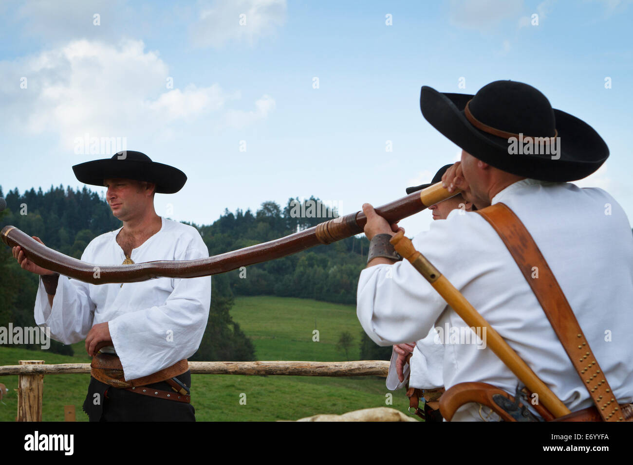 Eine Higlander von Beskiden in traditionellen Kostümen spielen Alphorn - "Trombita". Stockfoto