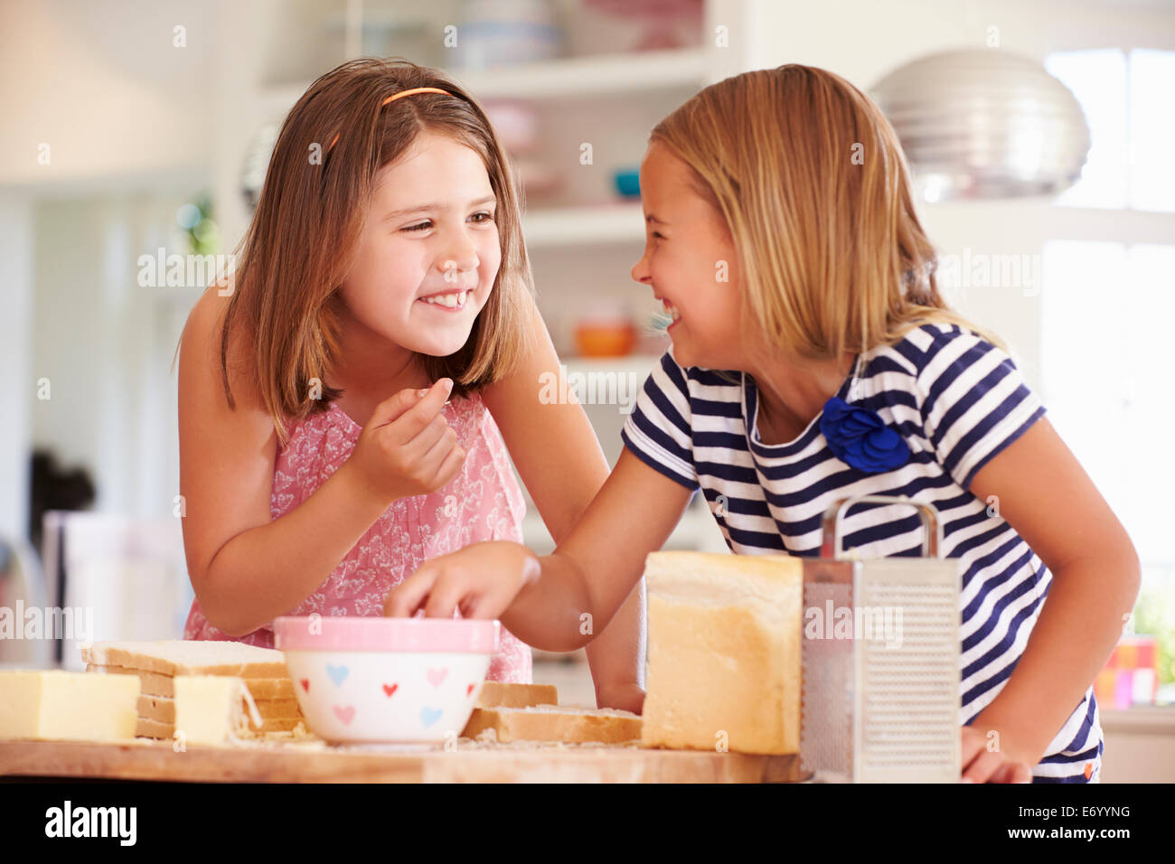 Mädchen, die Zutaten zu essen, während die Käse auf Toast Stockfoto