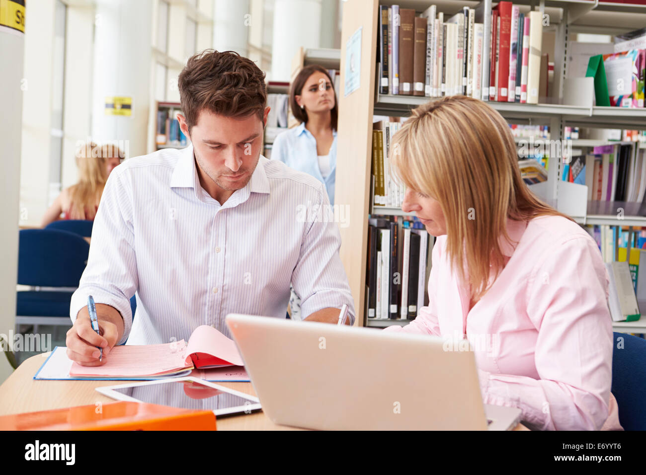 Lehrer helfen älteren Schüler mit Studien In Bibliothek Stockfoto
