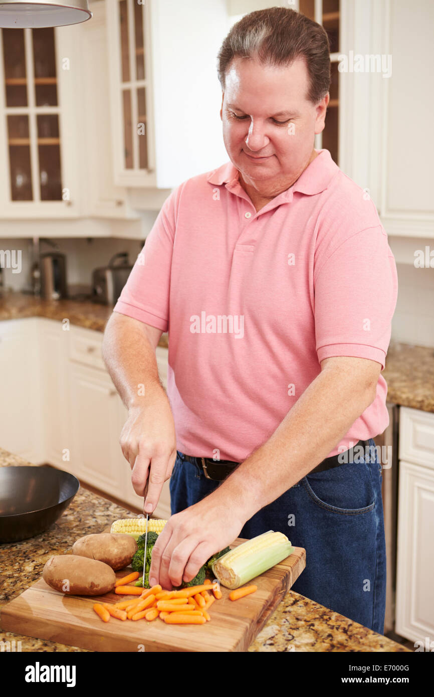 Übergewichtiger Mann vorbereiten Gemüse in der Küche Stockfoto