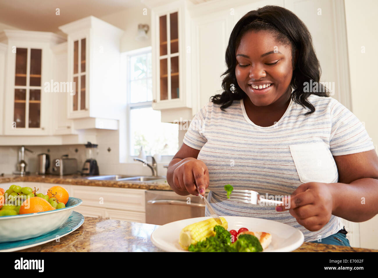 Übergewichtige Frau gesund Essen in der Küche Stockfoto