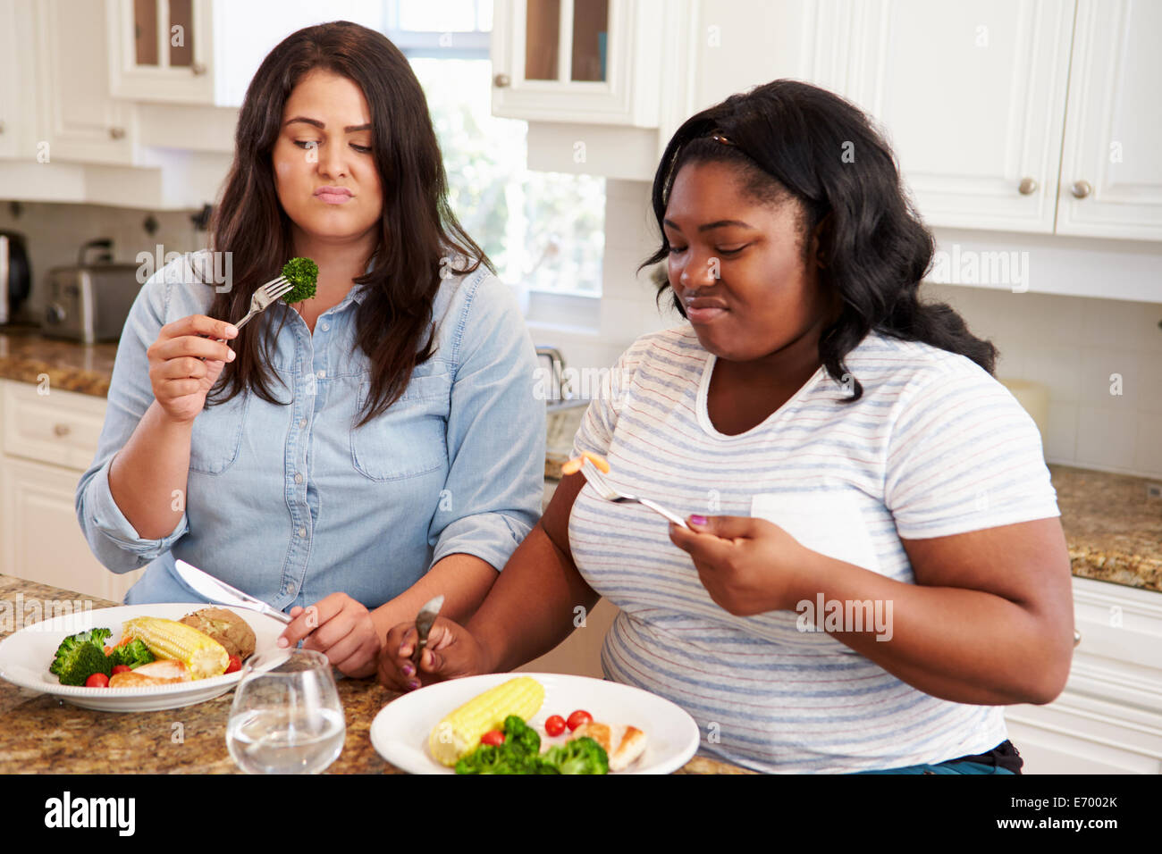 Zwei übergewichtige Frauen auf Diät gesunde Mahlzeit In der Küche Stockfoto