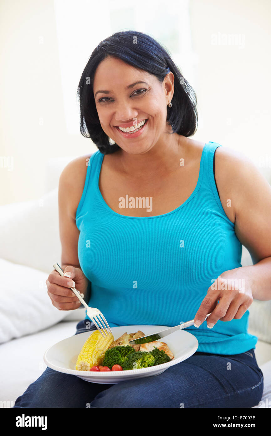 Übergewichtige Frau gesunde Mahlzeit auf Sofa Stockfoto