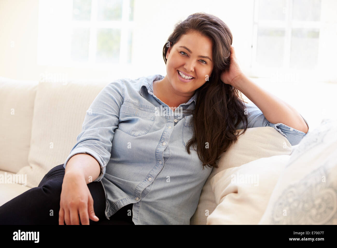 Porträt von übergewichtigen Frau sitzend auf Sofa Stockfoto