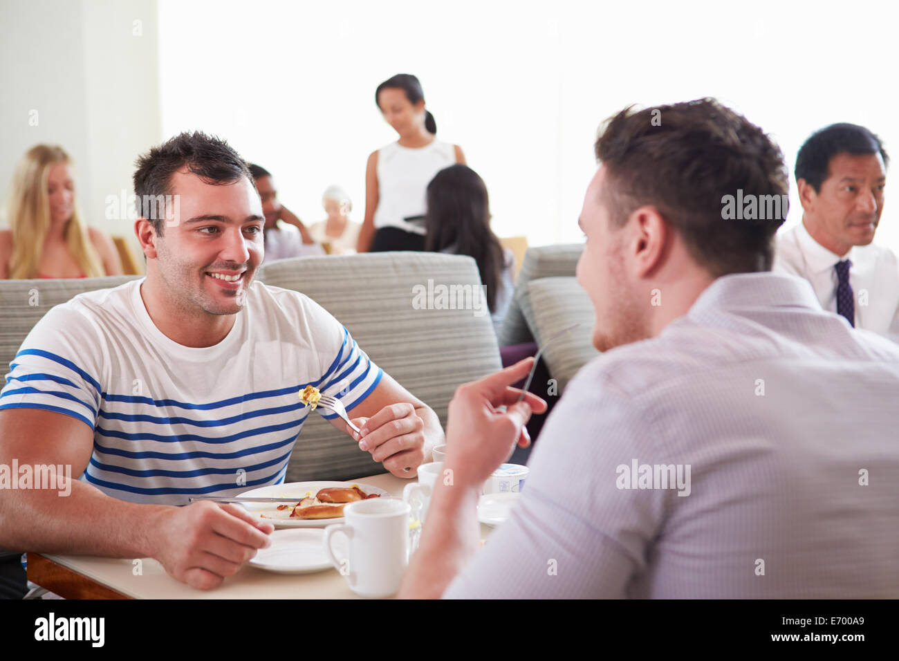 Zwei Männer genießen das Frühstück im Hotelrestaurant Stockfoto