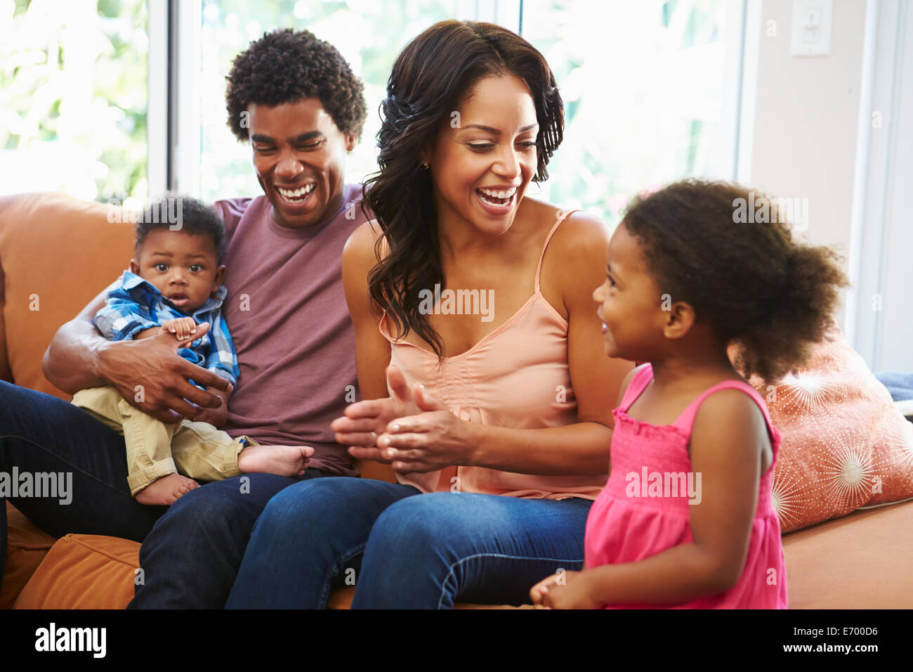 Junge Familie entspannend auf Sofa zusammen Stockfoto