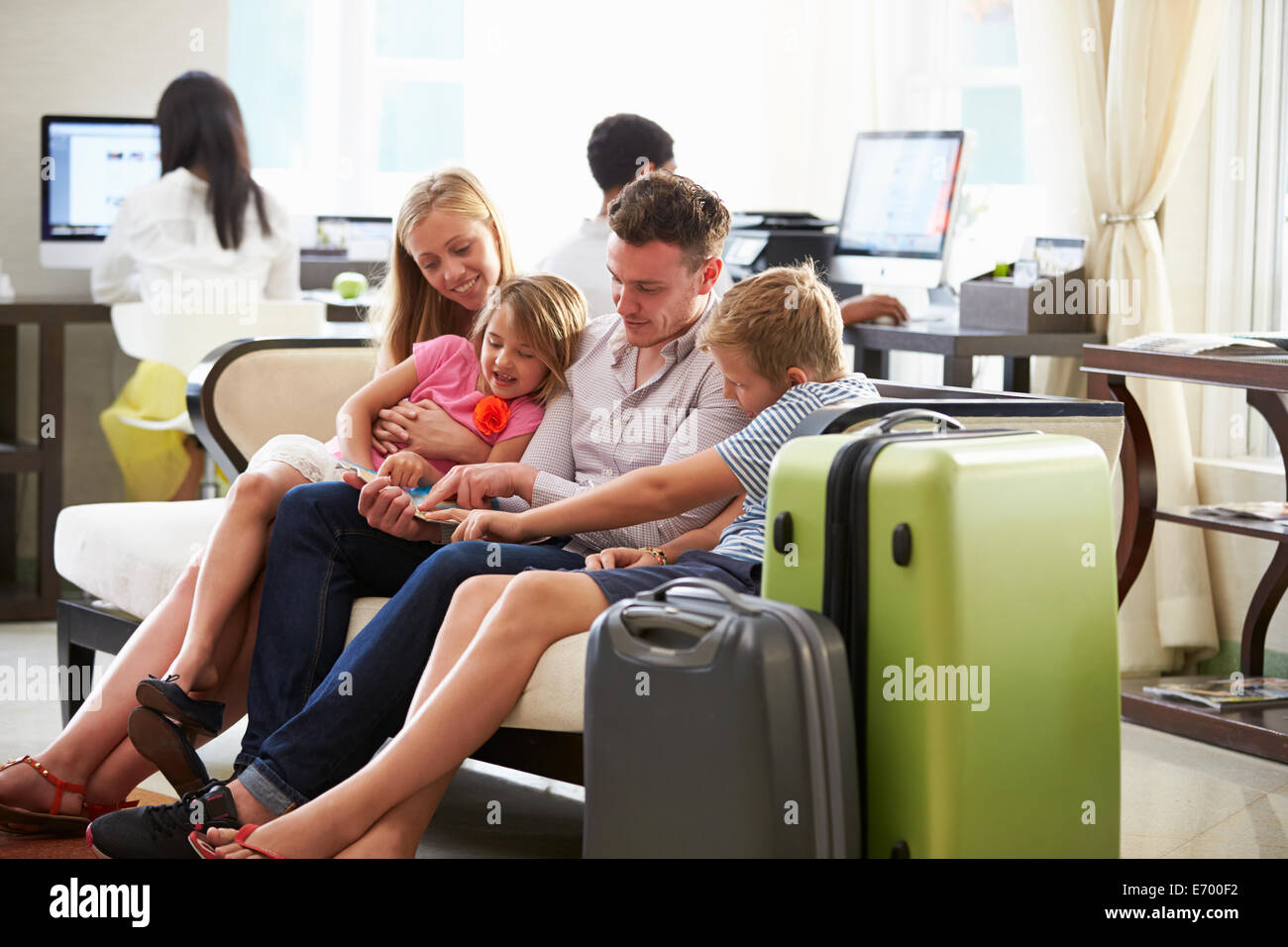 Familie In Hotellobby Blick auf Digital-Tablette Stockfoto