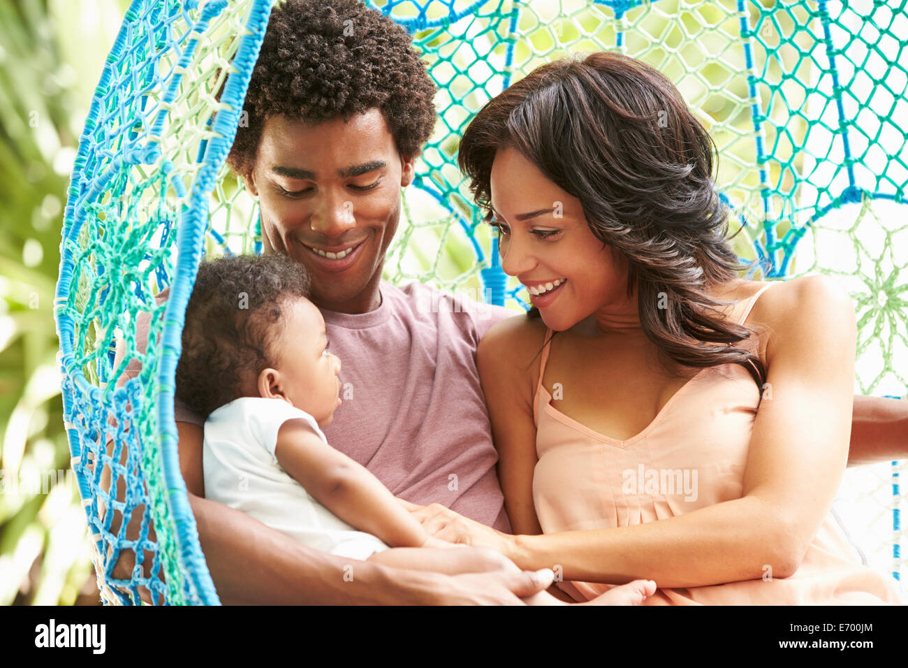 Familie mit Baby entspannend auf Garten-Schaukelsitz Stockfoto