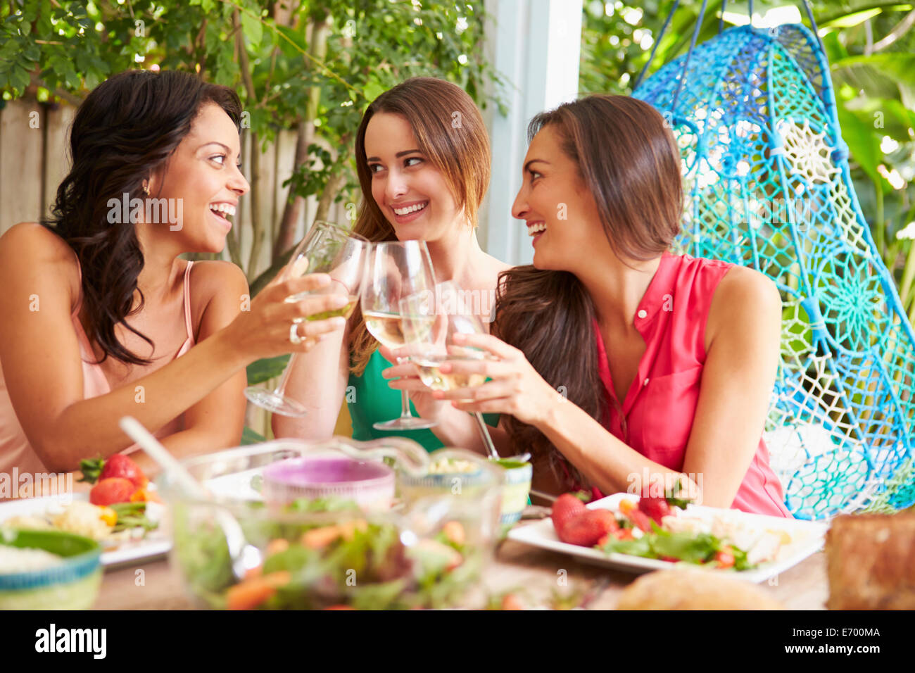 Drei Freundinnen, die Mahlzeit im Freien zu Hause genießen Stockfoto