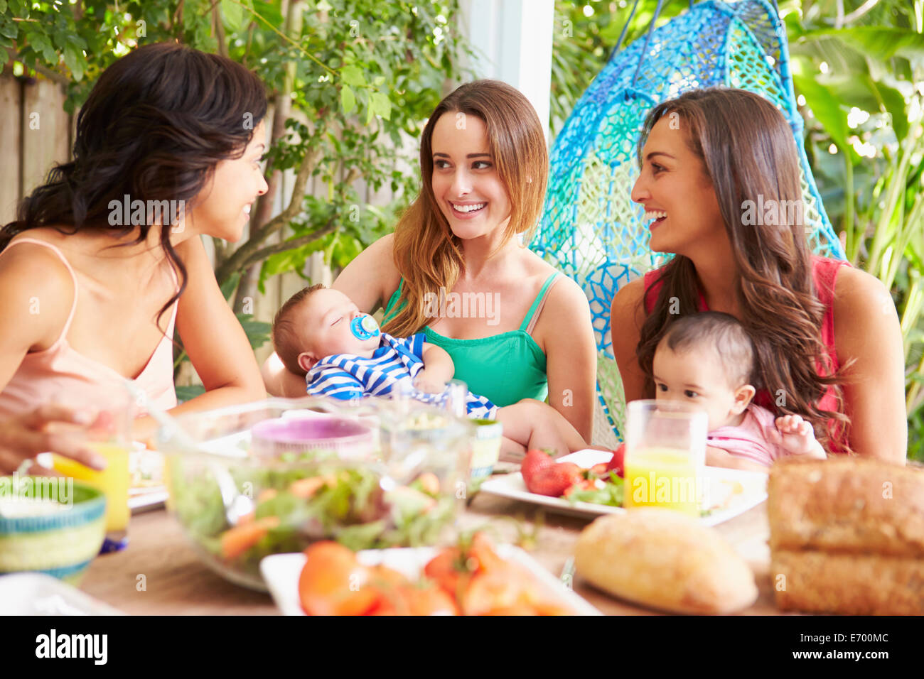 Gruppe von Müttern mit Babys Mahlzeit im Freien zu Hause genießen Stockfoto