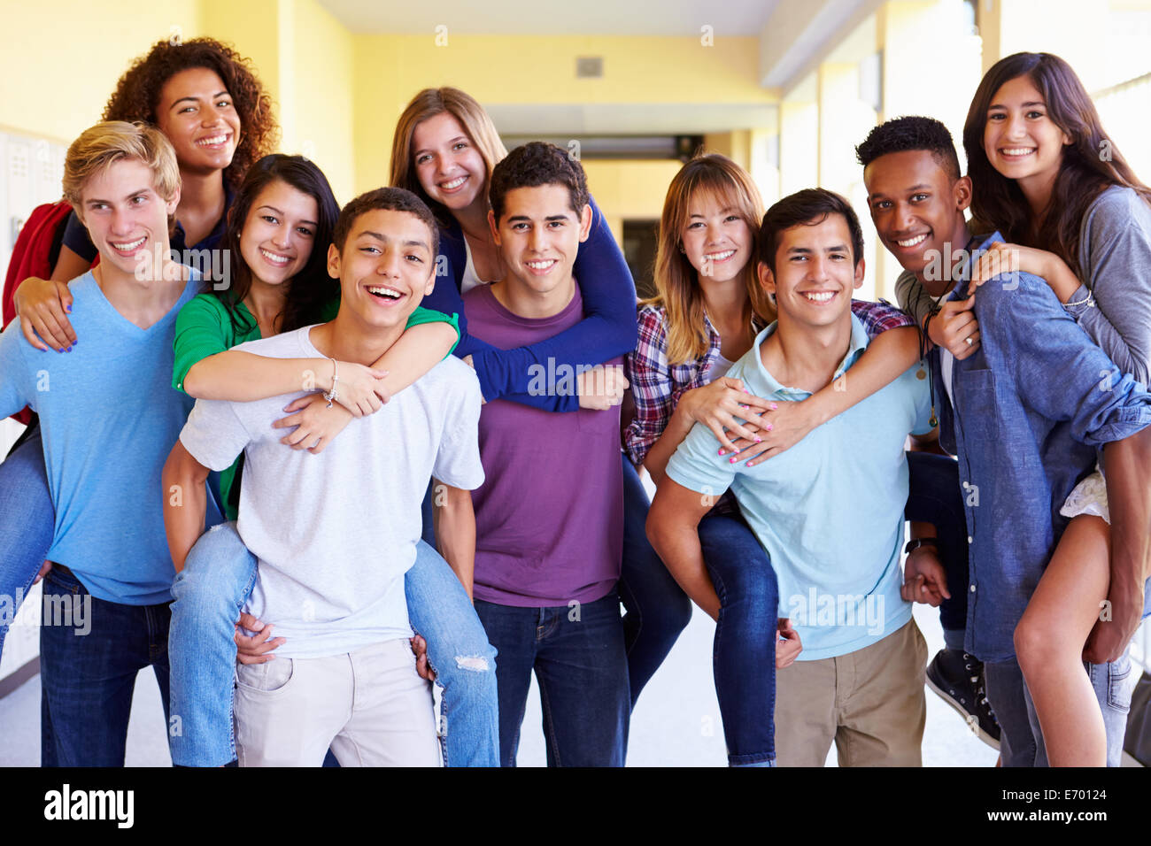 Gruppe von Schülerinnen und Schüler geben Piggybacks im Korridor Stockfoto