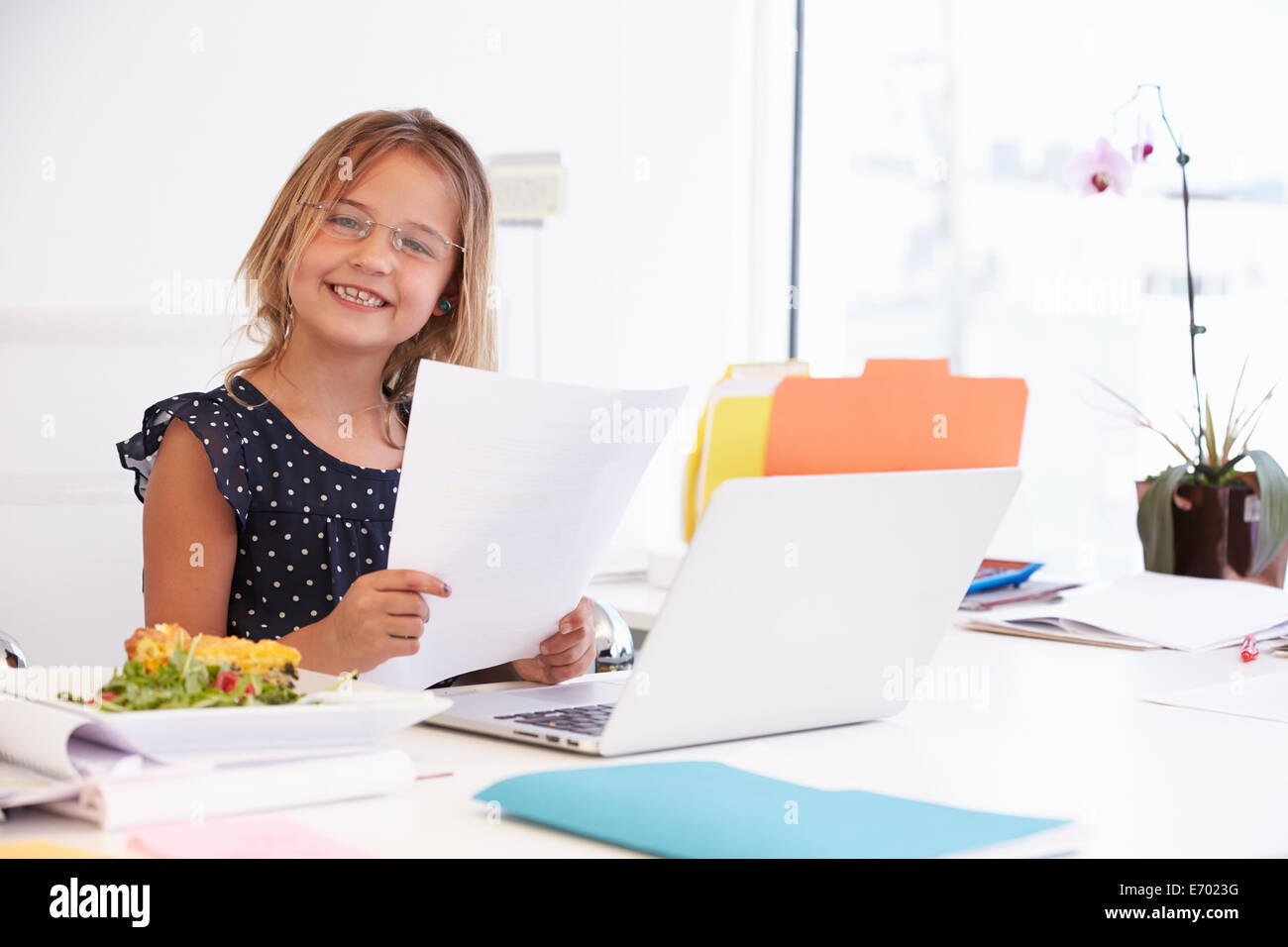 Mädchen, die vorgibt, Geschäftsfrau, die Arbeiten am Schreibtisch Stockfoto