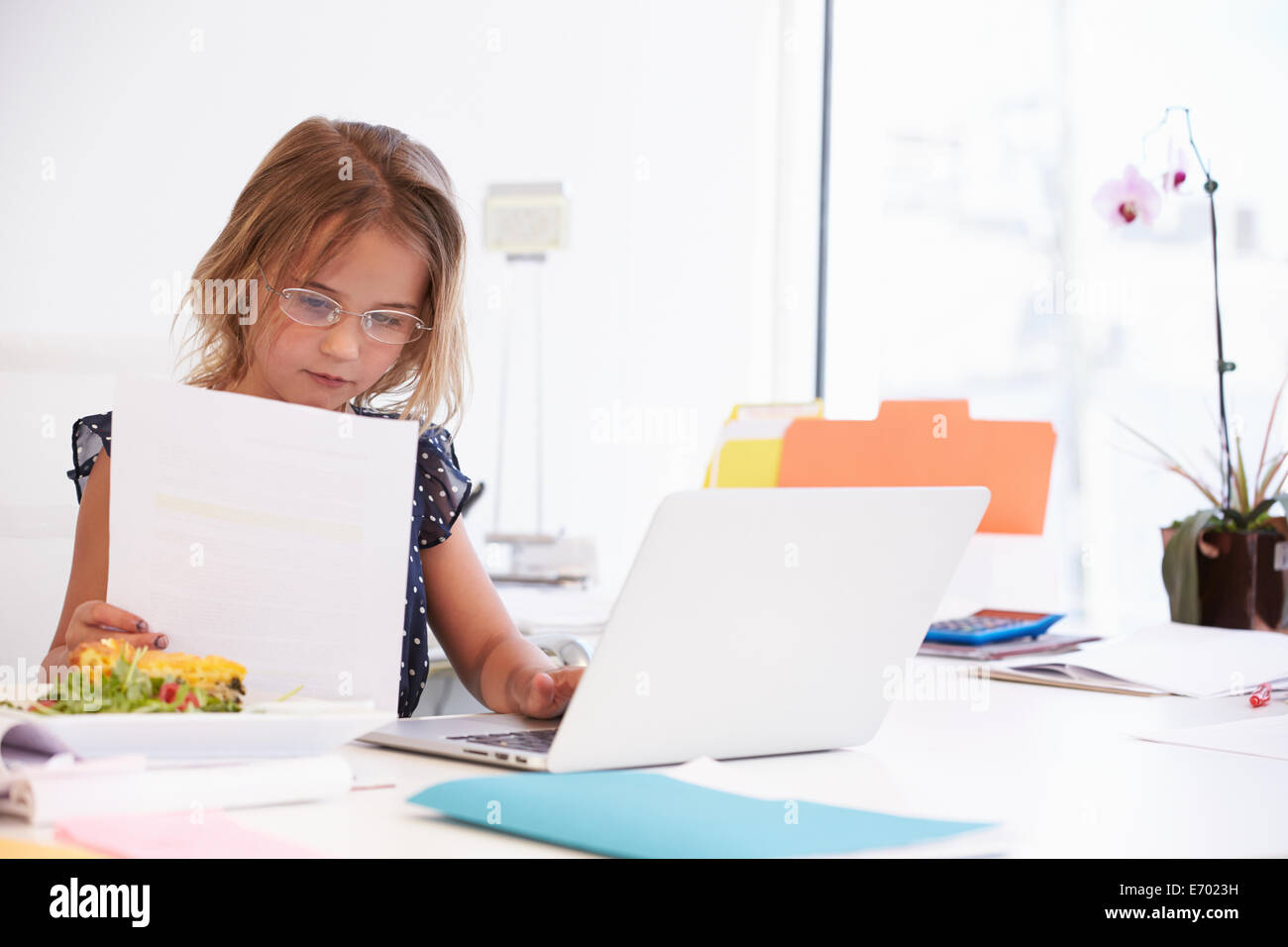 Mädchen, die vorgibt, Geschäftsfrau, die Arbeiten am Schreibtisch Stockfoto