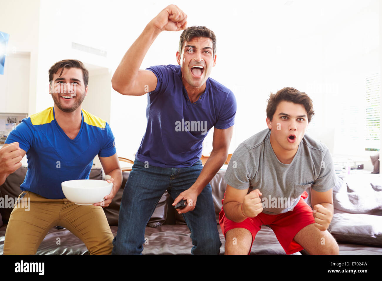 Gruppe von Männern auf Sofa beobachten Sport zusammen sitzen Stockfoto