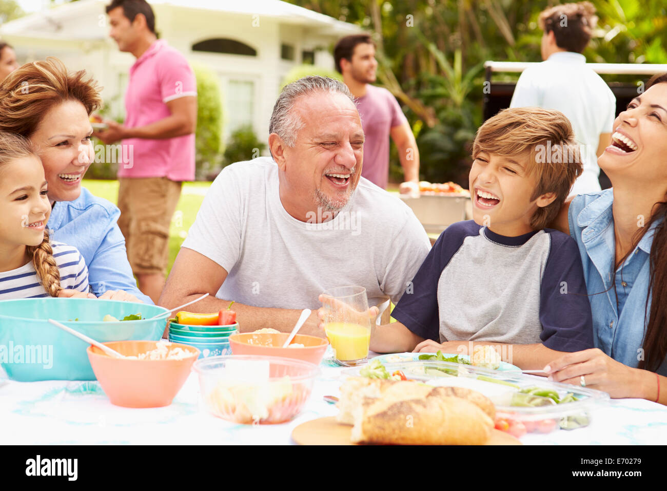 Multi-Generationen-Familie gemeinsame Mahlzeit im Garten genießen Stockfoto