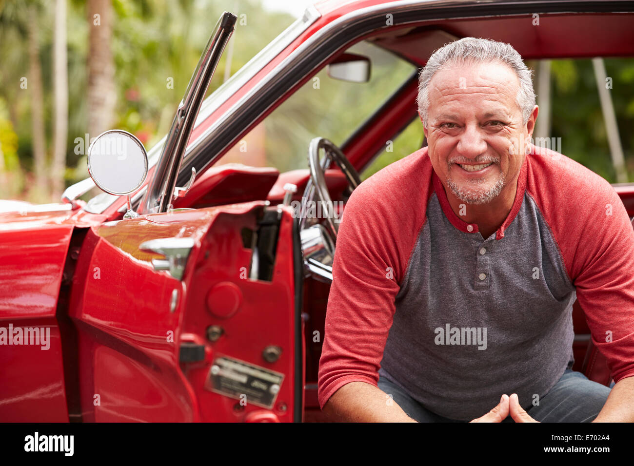 Ehemaliger Senior Mann sitzt im restaurierten Oldtimer Stockfoto