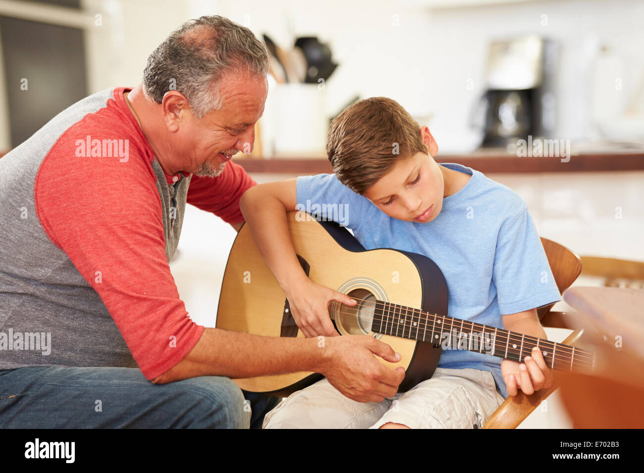 Großvater Lehre Enkel, Gitarre zu spielen Stockfoto