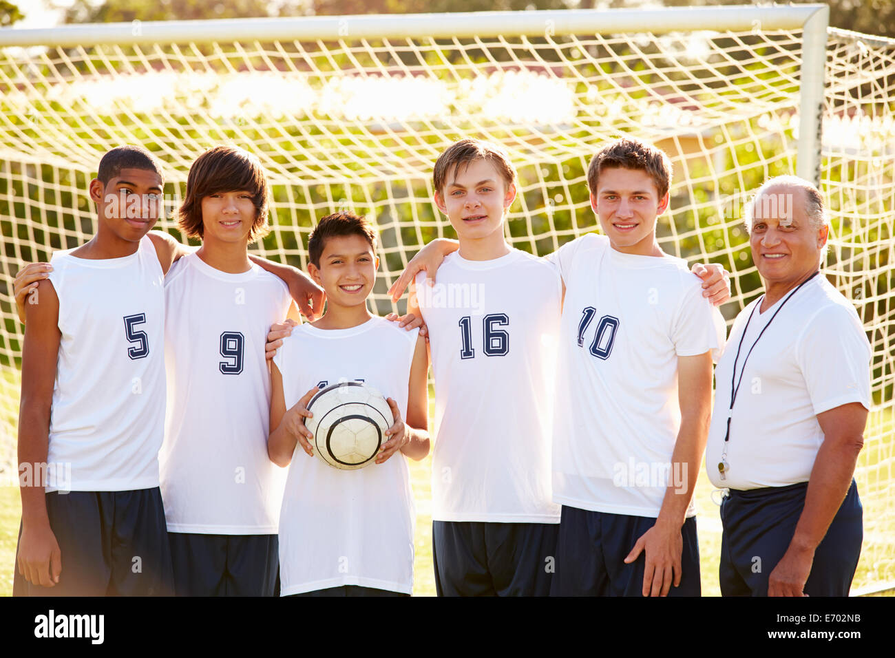 Mitglieder des männlichen High-School-Fußball-Team mit Trainer Stockfoto