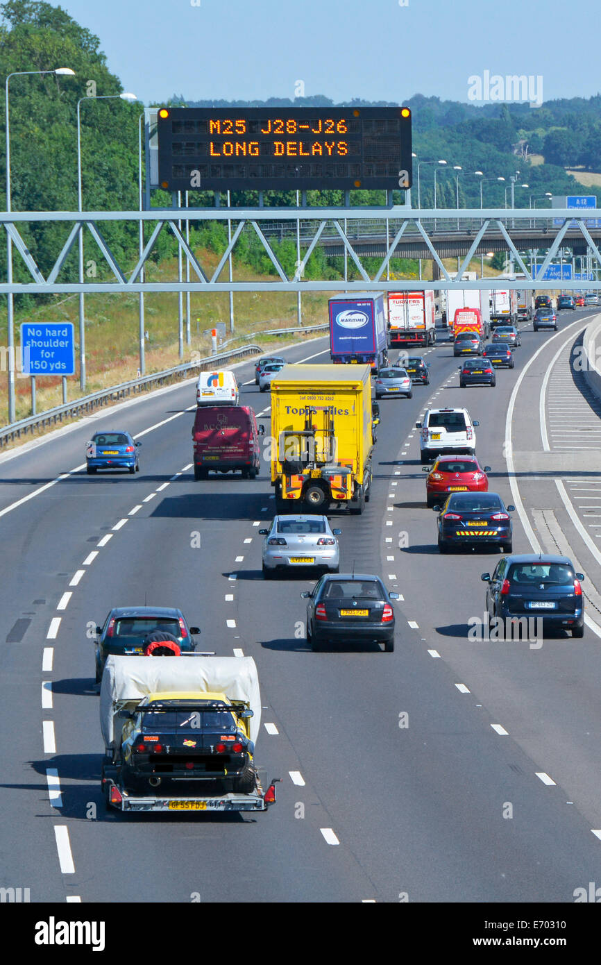 Autobahnverkehr & digitale elektronische Technologie Straßenschild mit Vorwarnung lange Verzögerungen im Uhrzeigersinn M25 Route nächste Kreuzung 28 Brentwood UK Stockfoto