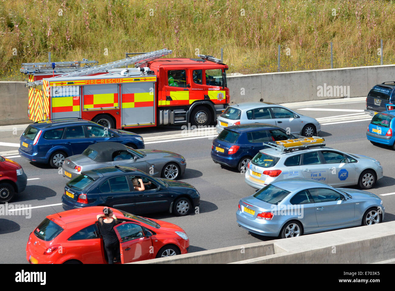 Autofahrer in massive Staus auf festgefahrene Autobahn mit Feuerwehrauto mit Standstreifen, Absturz auf einem heißen Sommertag zu erreichen Stockfoto