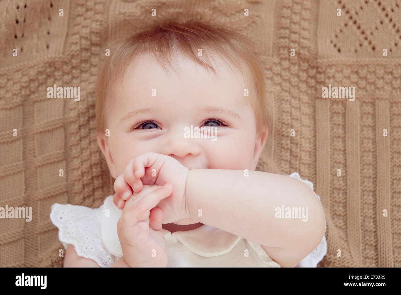 Porträt von lächelndes Babymädchen auf der Decke liegen hautnah Stockfoto
