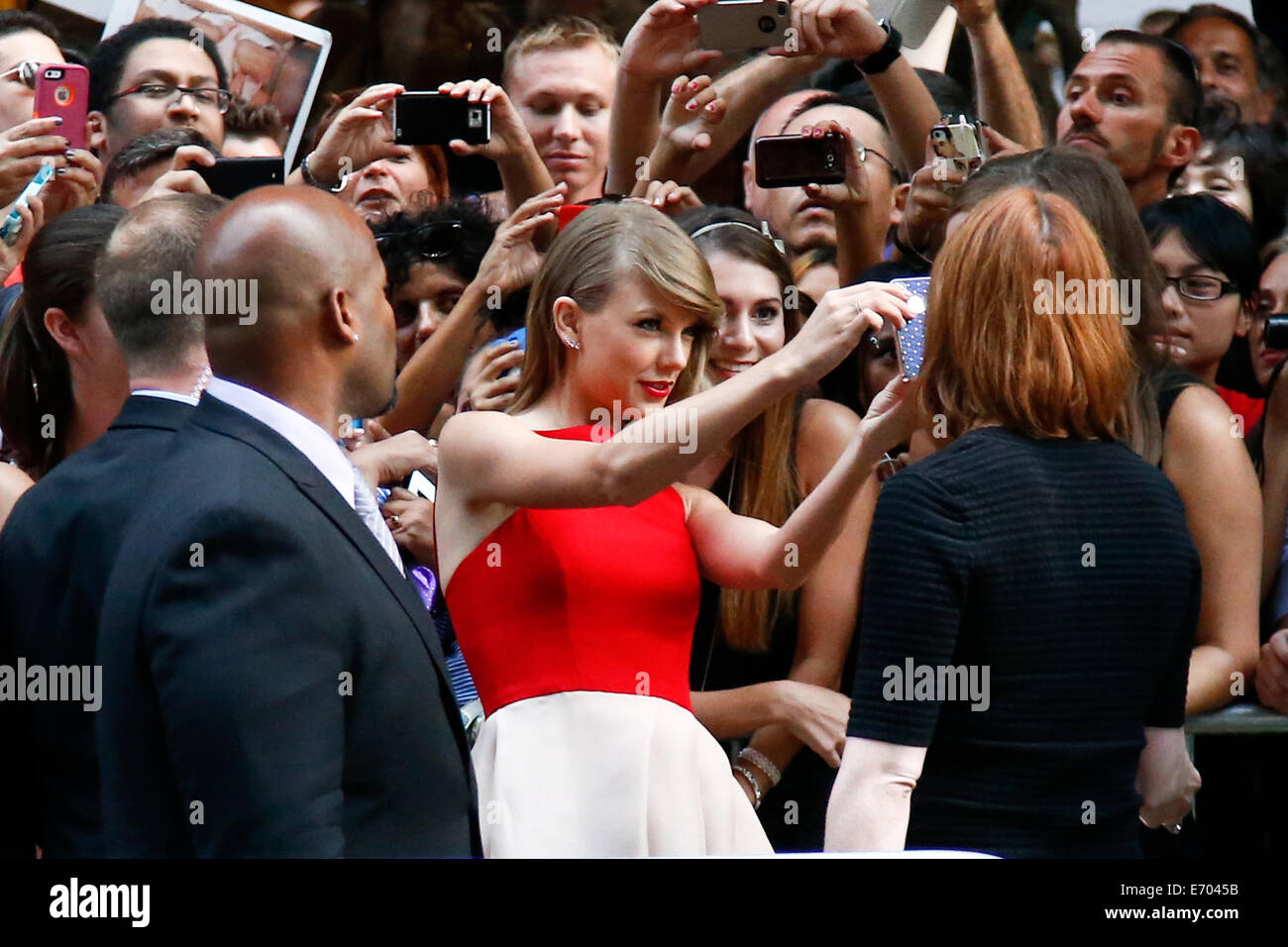 Sängerin Taylor Swift findet ein Selbstporträt mit einem Ventilator bei der Premiere von "The Giver" im Ziegfeld Theatre am 11. August 2014. Stockfoto