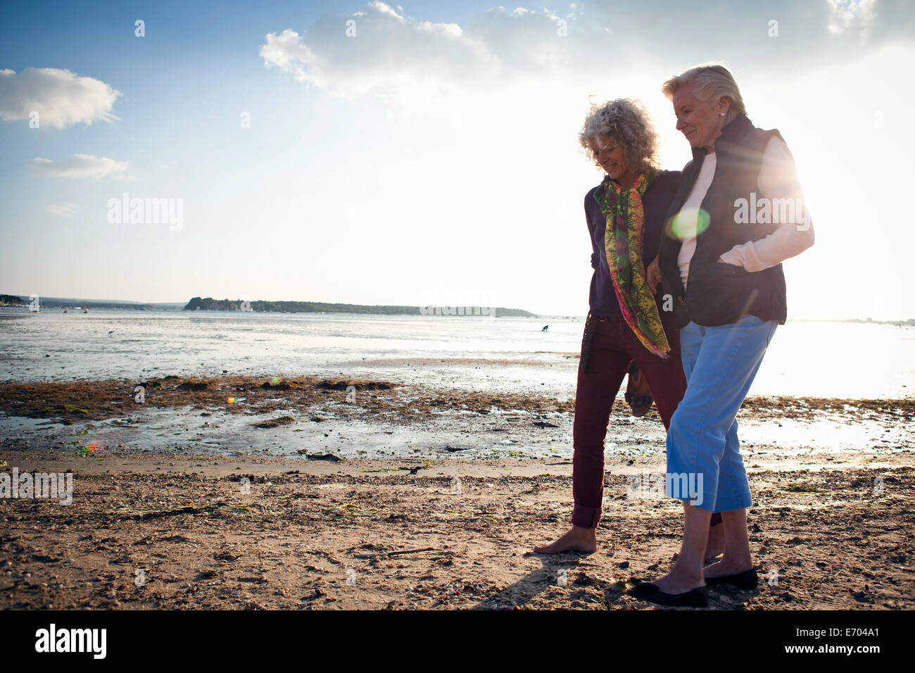 Mutter und Tochter zu Fuß am Strand Stockfoto