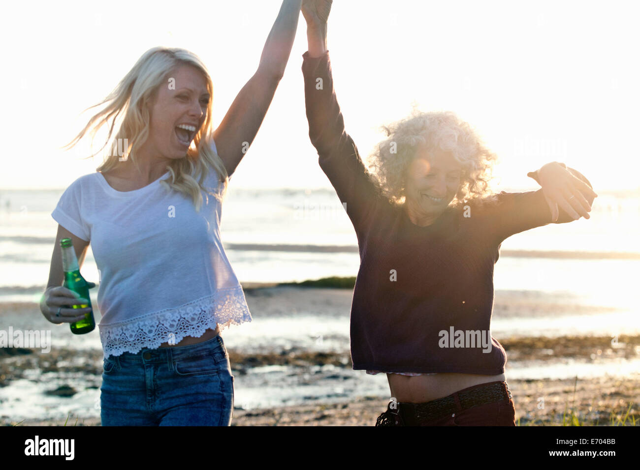 Mutter und Tochter tanzen am Strand von Bournemouth, Dorset, Großbritannien Stockfoto