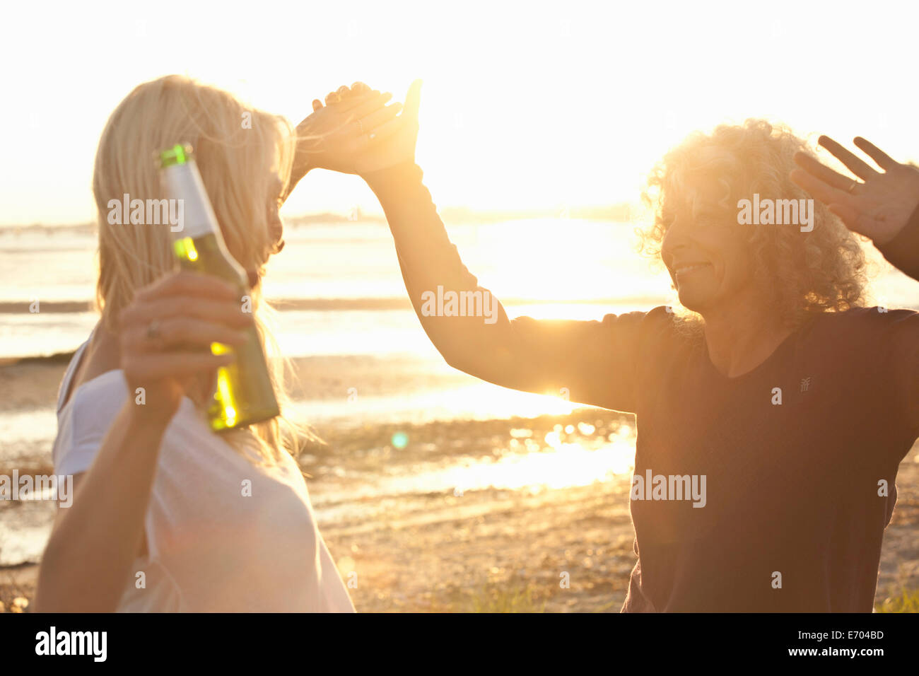 Reife Mutter und Tochter tanzen am Strand von Bournemouth, Dorset, Großbritannien Stockfoto