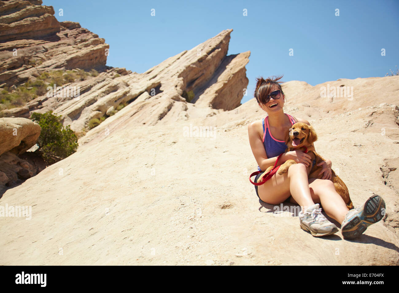 Junge Frau mit Labrador-Welpe auf Schoß Stockfoto