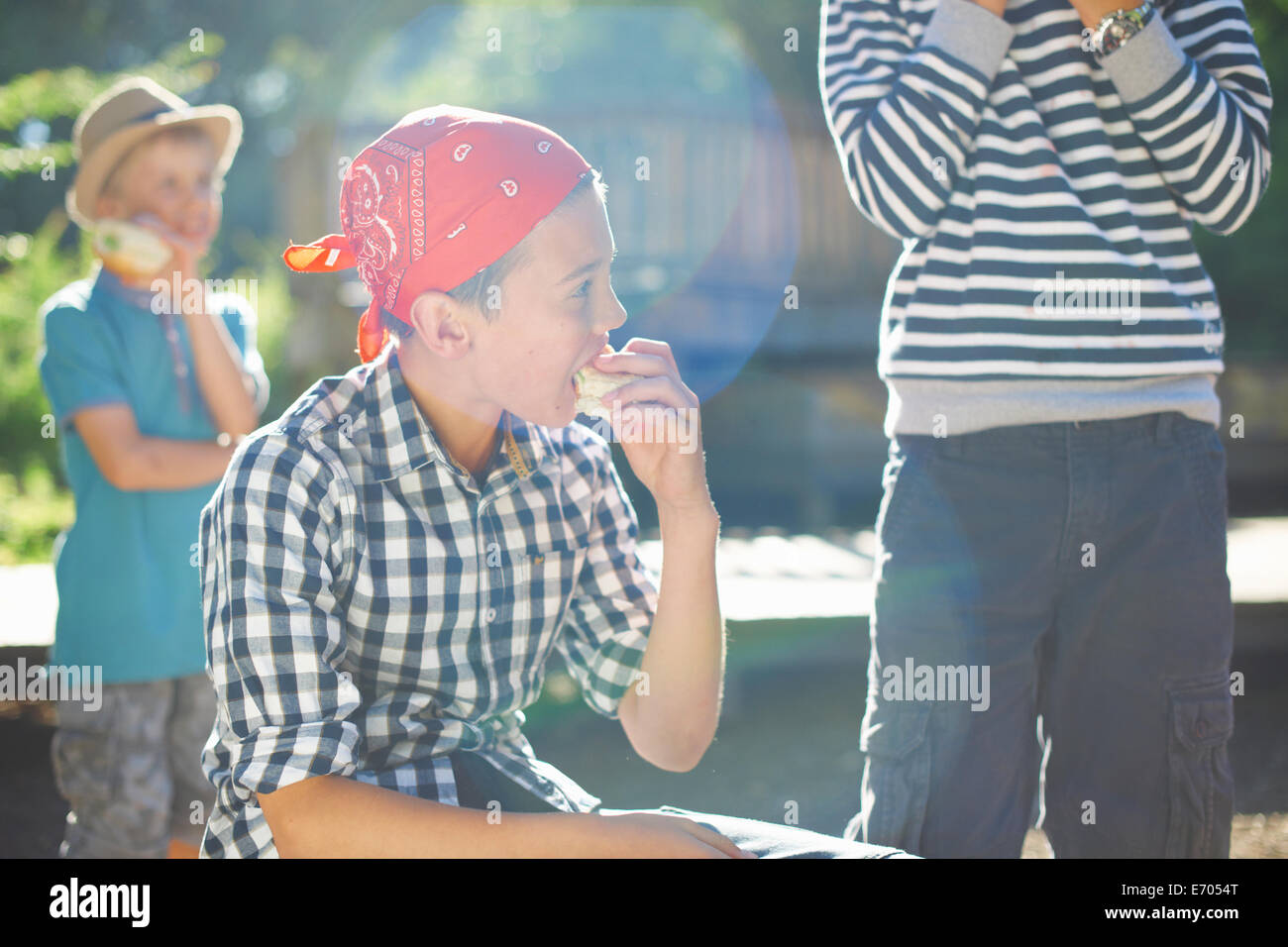 Drei junge Burschen mit Mittagessen im park Stockfoto