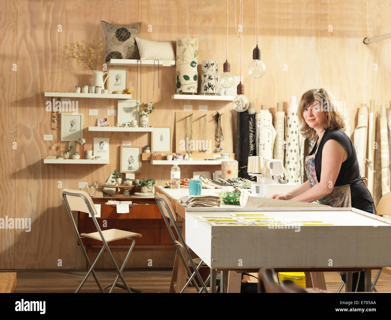 Frau am Arbeitstisch in Hand-Druck-Textil-Werkstatt Stockfoto