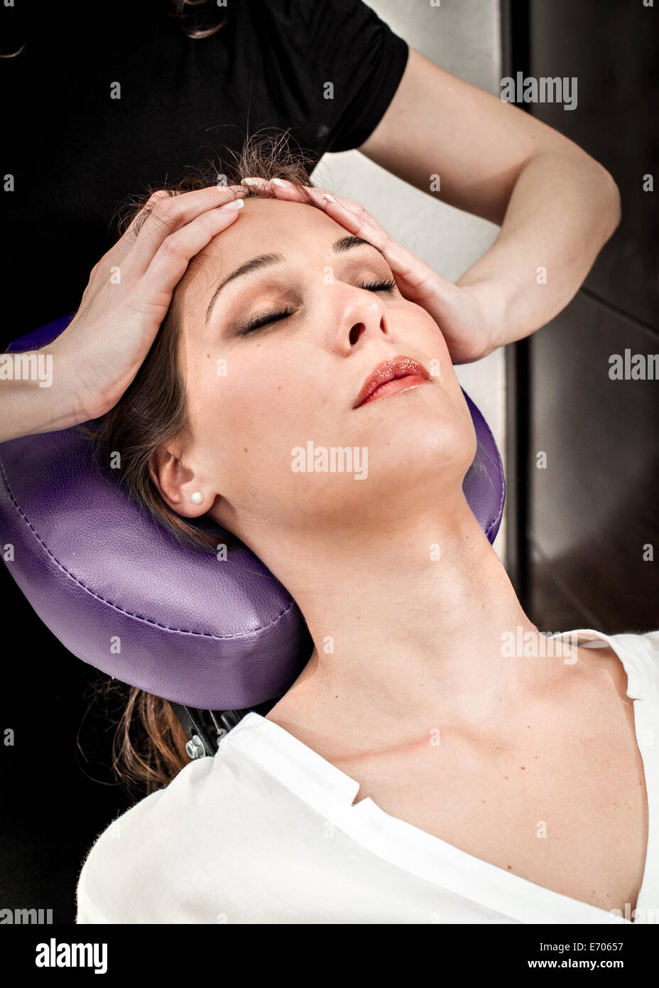 Weibliche Masseur massiert junge Frau Stirn im Beauty-salon Stockfoto