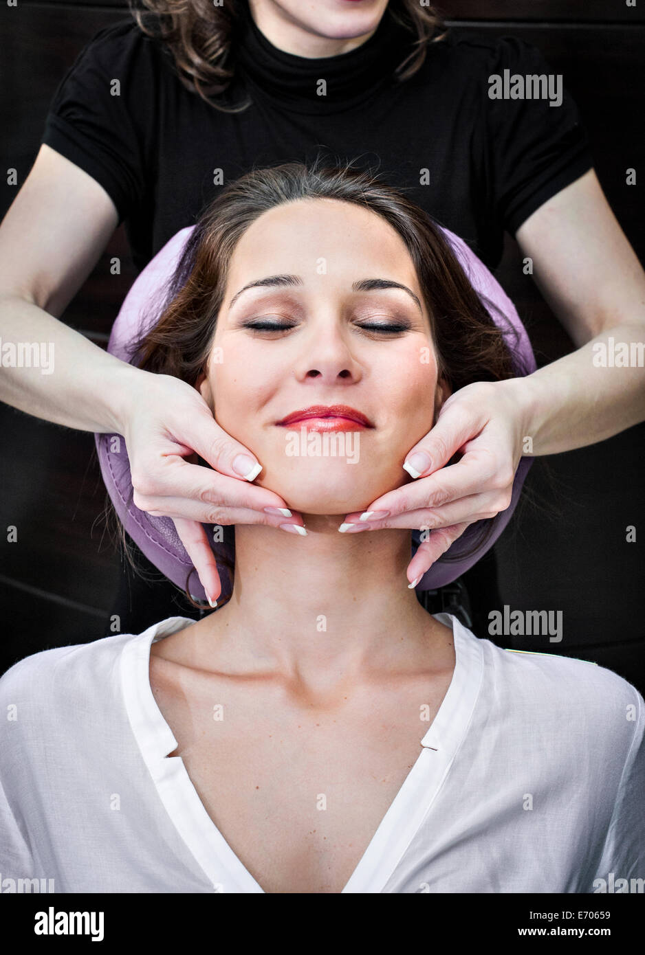 Weibliche Masseur massiert junge Frau Kinn im Beauty-salon Stockfoto
