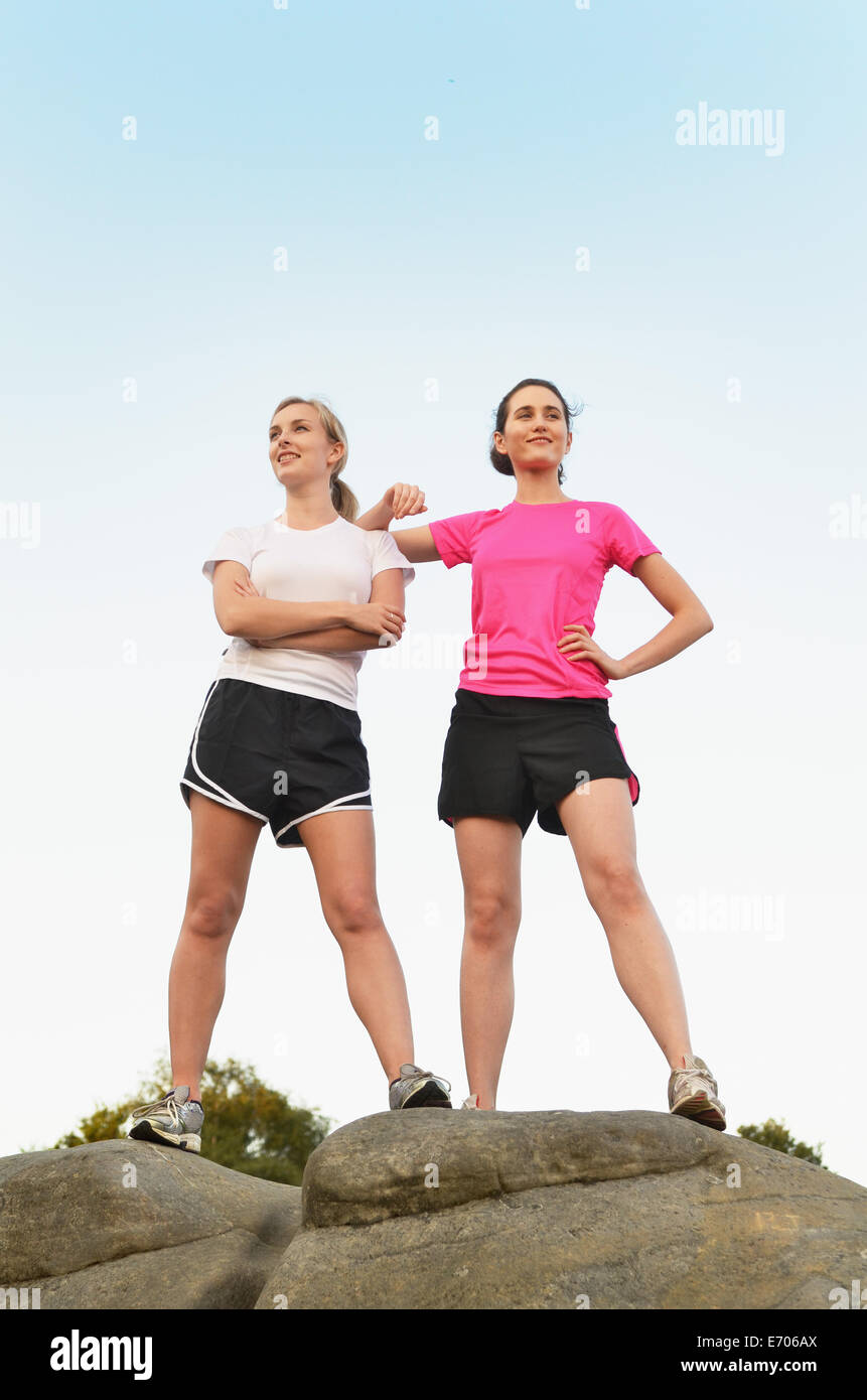Porträt von zwei stolzen LäuferInnen auf Felsformation Stockfoto