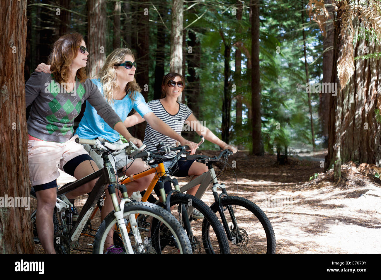 Porträt von drei Frauen Mountainbiker im Wald Stockfoto