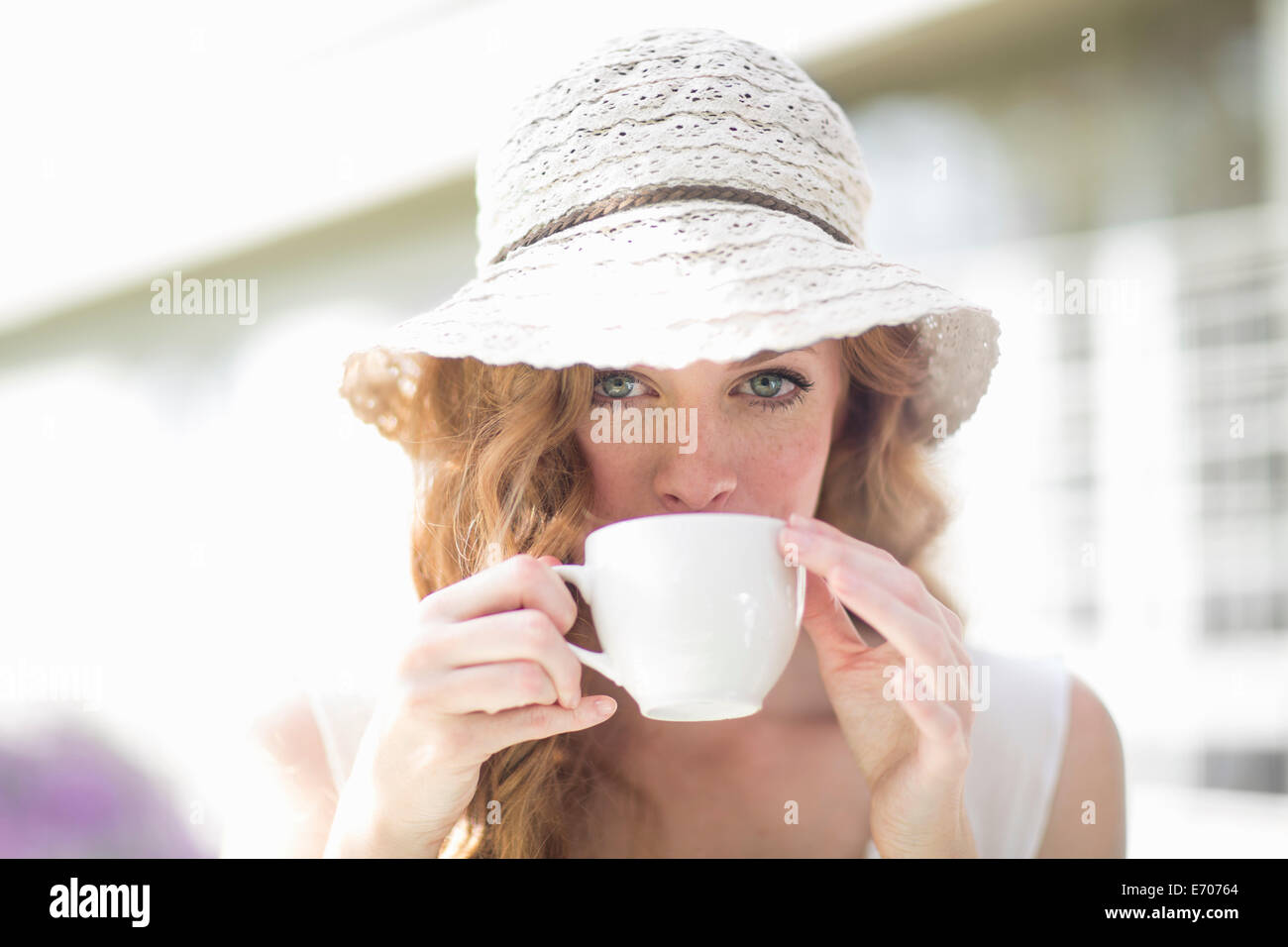 Porträt der jungen Frau aus Kaffeetasse im Straßencafe trinken Stockfoto