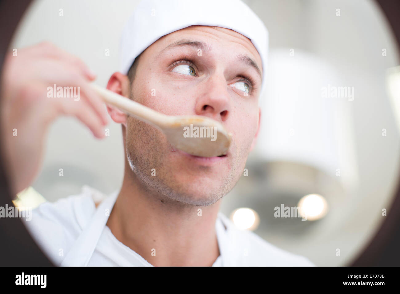 Männlichen Chef schmeckendes Essen vom Topf in Großküchen Stockfoto