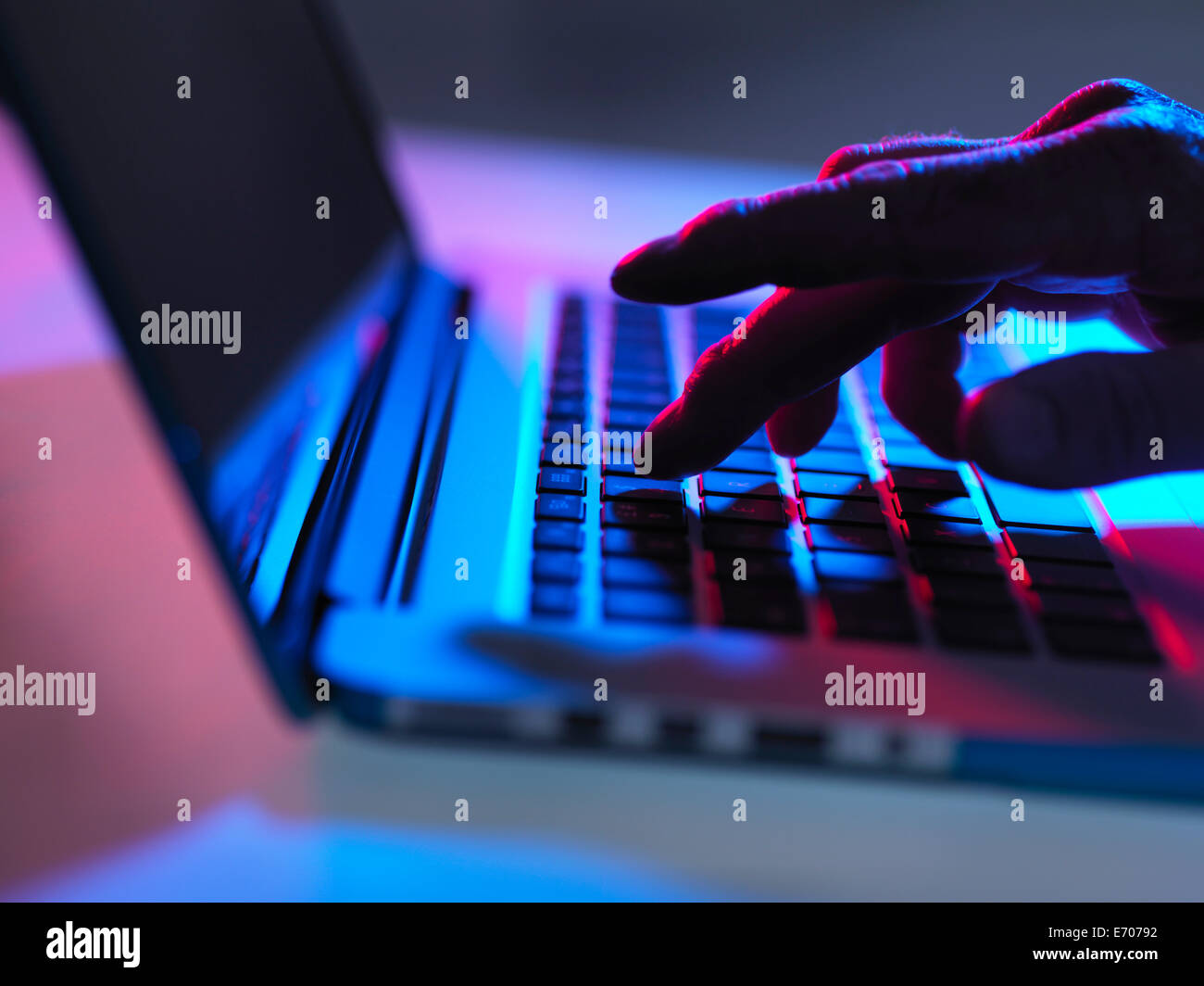 Silhouette der männlichen Hand in der Nacht auf Laptoptastatur tippen Stockfoto