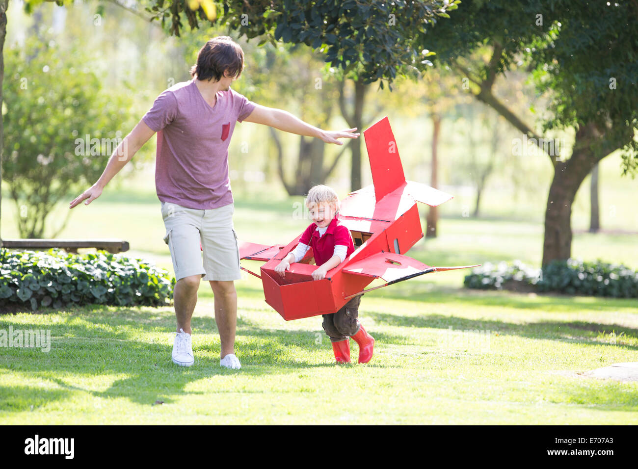 Vater und Sohn läuft mit Spielzeugflugzeug im park Stockfoto