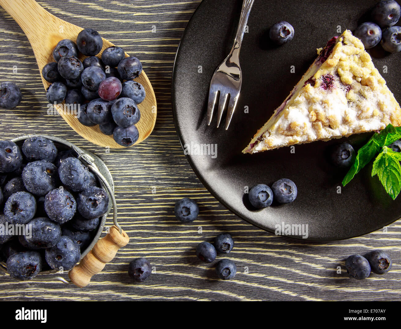 Heidelbeer-Kuchen und frisches Obst angeordnet auf einem Holztisch Stockfoto
