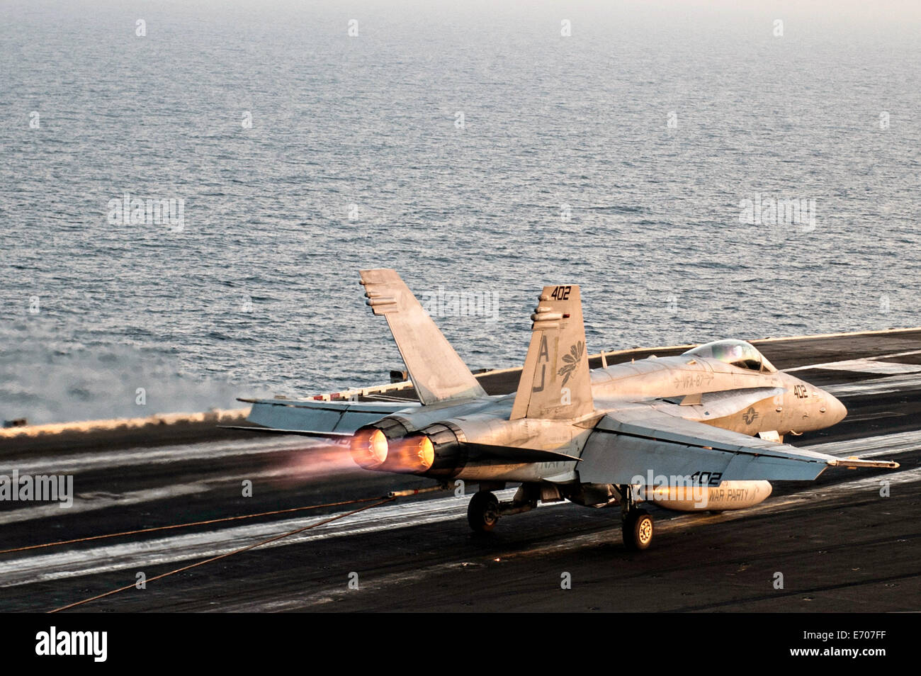 Ein Kampfflugzeug der US Navy F/A - 18C Hornet führt einen verhafteten landen auf dem Flugdeck des Flugzeugträgers USS George H.W. Bush 29. August 2014 in den Persischen Golf. Die Piloten fliegen gezielte Luftangriffe gegen Extremisten bekannt als der islamische Staat im Irak und in der Levante. Stockfoto