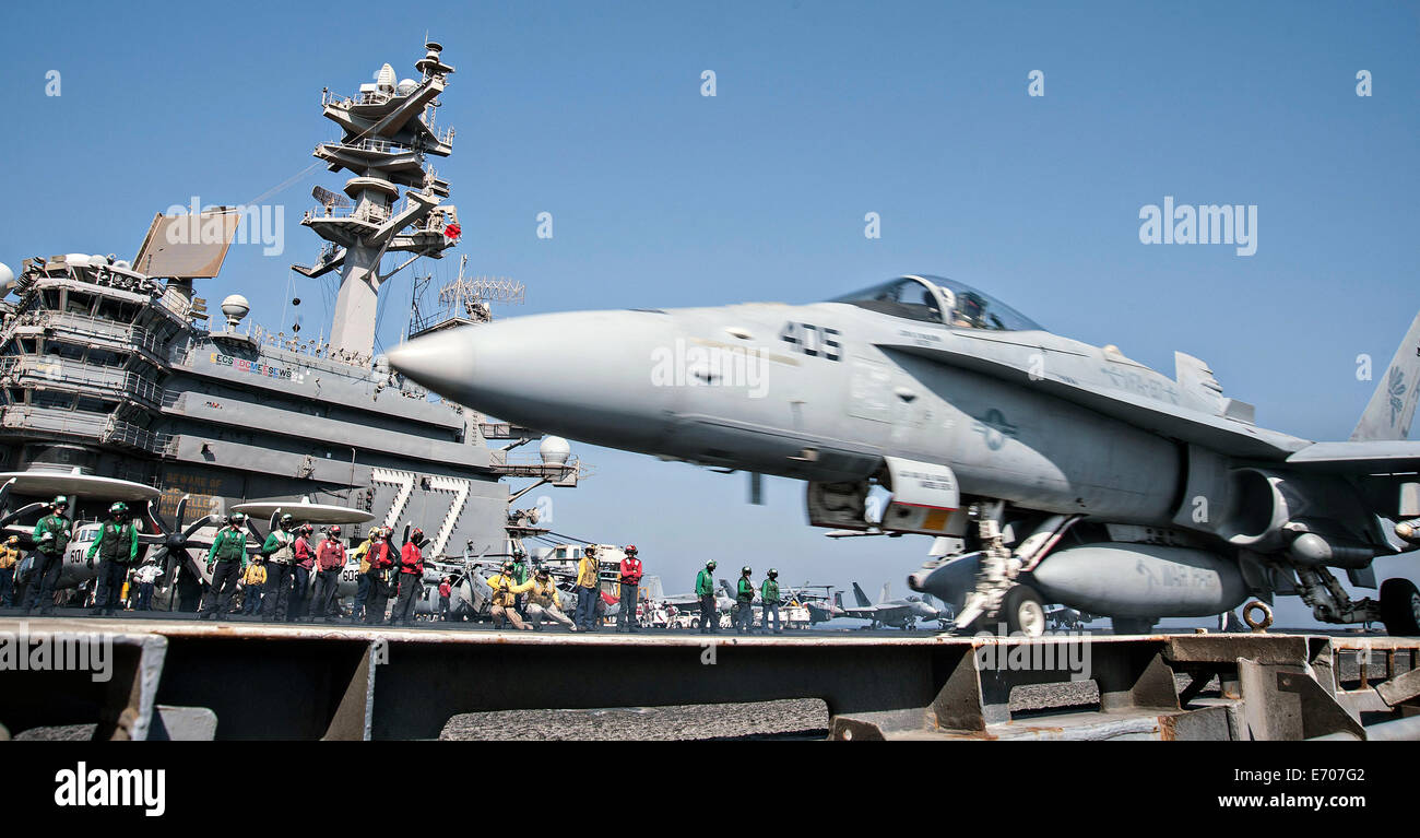 Ein Kampfflugzeug der US Navy F/A - 18C Hornet startet aus dem Flugdeck des Flugzeugträgers USS George H.W. Bush 23. August 2014 in den Persischen Golf. Die Piloten fliegen gezielte Luftangriffe gegen Extremisten bekannt als der islamische Staat im Irak und in der Levante. Stockfoto