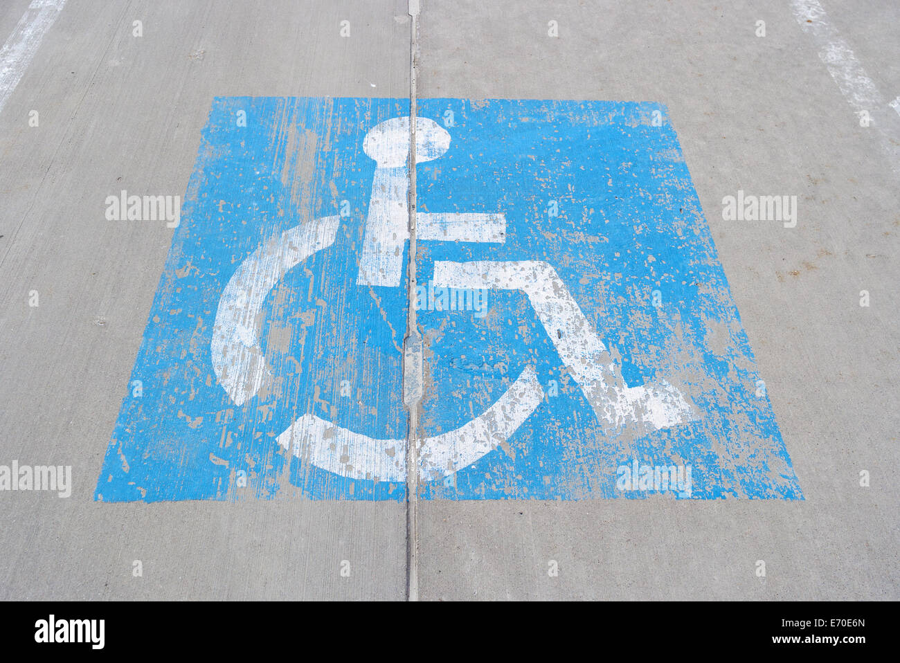 Eine alte und verwitterte blaues Behinderte Schild gemalt auf Beton. Stockfoto