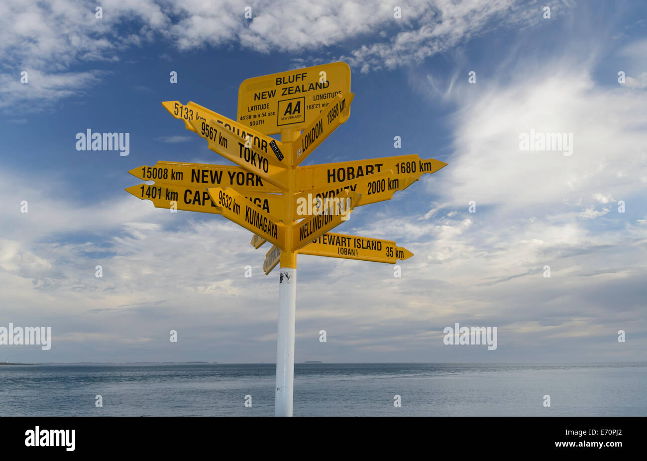 Gelbe Schilder mit weltweiten Destinationen, das Meer auf der Rückseite, Bluff, Südinsel, Neuseeland Stockfoto