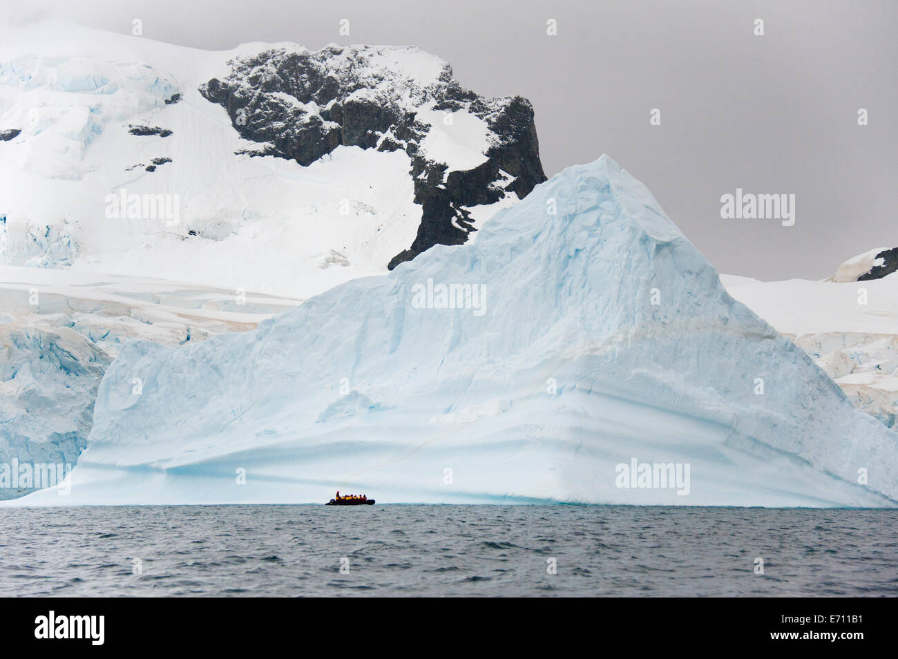 Menschen in kleinen inflatible Zodiac Rib-Boote vorbei an Eisberge und Eisschollen auf dem ruhigen Wasser Stockfoto
