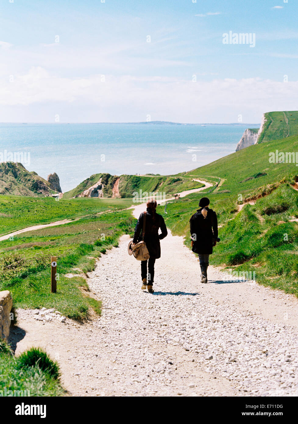 Zwei Frauen zu Fuß auf einem Küsten-Wanderweg entlang der Klippen. Stockfoto